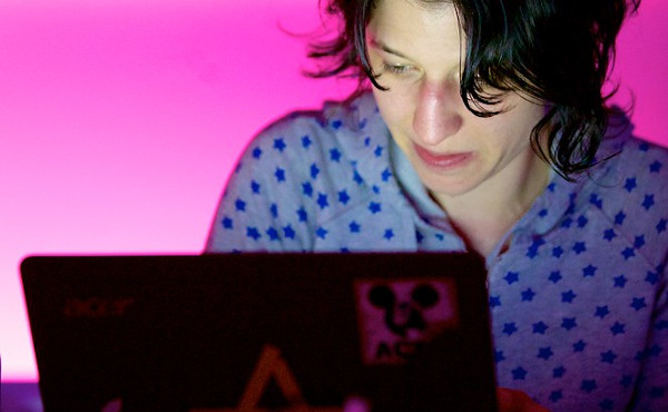 Julia Seeliger am Laptop mit pinkem Hintergrund